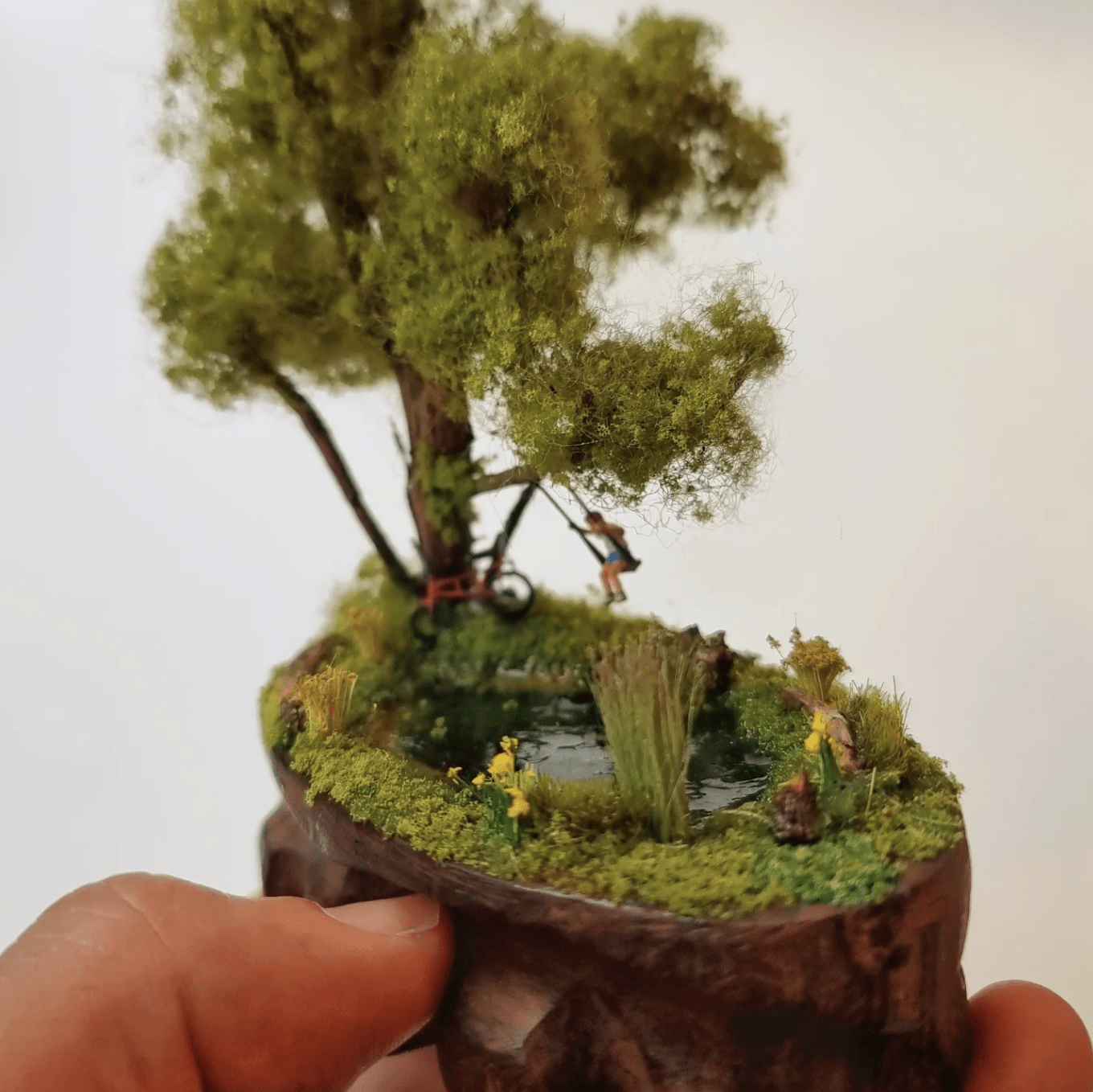 Boy on a swing over a pond — miniature diorama